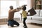 African father and little son fighting playing with pillows