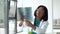 African female doctor with glasses looking at x-ray of lungs while sitting at table in modern clinic