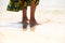 African female feet standing on the sea shore