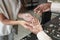 African female shop assistant showing pearl necklace to buyer