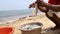 An African fisherman holds freshly caught fish from his bucket at the beach