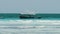 African Fishing Boat in Ocean Sways on Waves a Flock of Seagulls Flies above it