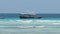 African Fishing Boat in Ocean Sways on Waves a Flock of Seagulls Flies above it