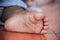 African foot of baby sitting on wooden table