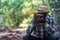 African freedom man traveler holding camera with backpack standing in the green natural forest