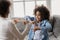 African girl with hearing loss practicing body language with therapist.