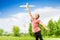 African girl holding airplane toy in green field