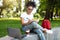 African Girl Preparing Lesson Using Laptop Taking Notes In Park