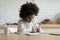 African girl sitting doing homework learn school subject at home