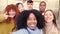 African girl taking a selfie with diverse friends outdoors