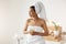 African girl with towel on head holding glass smiling looking in side resting in spa resort.