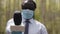 African journalist with medical mask doing an interview, Pointing microphone to the camera