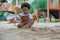 African little boy with afro hair enjoy playing sand on playground outdoors