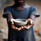 African little boy holding an empty clay bowl, selective focus, shallow DOF. poverty