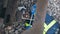 African machine engineer technician lying down and wearing a helmet, groves and safety vest is using a wrench to repair the train