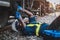 African machine engineer technician wearing a helmet, groves and safety vest is using a wrench to repair the train