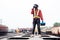 African machine engineer technician wearing a helmet, groves and safety vest is using a wrench to repair the train with talking by