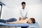 African male doctor massage therapist massaging back and shoulder blades of young woman