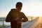 African male runner touching smartwatch, using fitness app, getting ready to run in the early morning. He is standing on