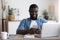 African male worker using both phone and computer in workplace