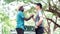 African man and asian man shaking hands over a deal with car and green natural background