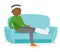 African man with broken leg sitting on the couch.