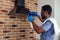 African man cleaning cooktop cooker hood at home ,Brick wall background