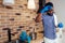 African man cleaning cooktop cooker hood at home ,Brick wall background