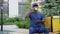 African man courier food delivery sitting on bench uses tablet drinking coffee