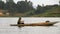 African Man Paddles Dugout Canoe