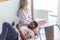 African man reading papers while resting on knees of his caucasian girlfriend