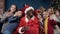 African man in santa claus costume and cute kids waving to the camera.