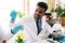 African man scientist researcher use a lab dropper to drip a substance into a conical flask for analysis of liquids in the lab.