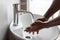 African Man Washing Hands Under In Wash-Basin In Bathroom, Closeup