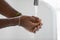 African man washing his hands under flowing water closeup image