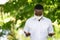 African man wear white shirt and face mask for virus protection with text Pray for the World corona virus covid-19 on green nature