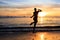 African men jumping at Sunset in Tarrafal beach in Santiago is