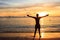 African men raising arms up at Sunset in Tarrafal beach in San