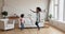 African mom and little daughter listen music dancing at home