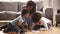 African mother and little kids sitting on warm floors drawing