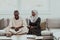 African Muslim couple at home in Ramadan reading Quran holly Islam book.