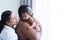 African Nigerian father holding cute newborn baby on shoulder in arms with Asian mother smiling looking at infant with love at