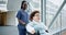 African nurse, woman and wheelchair in corridor, hospital and happy for conversation, kindness or helping hand. Doctor