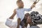 African parents and little son having fun with wood airplane on the beach - Family people having fun together outdoor