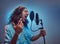 African Rastafarian singer male wearing a blue shirt and beanie emotionally writing song in the recording studio.