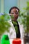 African researcher taking green leaf sample from petri dish putting under microscope