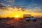 African safari vehicle stops in the Kalahari desert for dramatic sunset