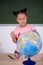 African schoolgirl looking globe with chalk background