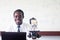 African science teacher teaching and smiling in the stem class with microscope and computer