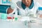 African scientist, technical assistant in lab coat, protective hat and gloves optimizes PCR testing for SARS-CoV-2 virus in modern